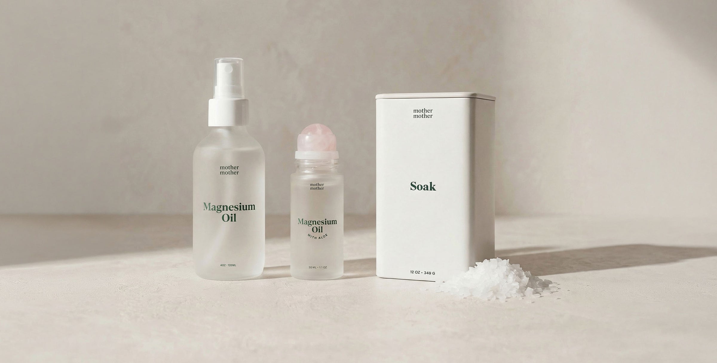 magnesium oil in a glass bottle and roller, plus a white magnesium bath soak tin on a neutral background